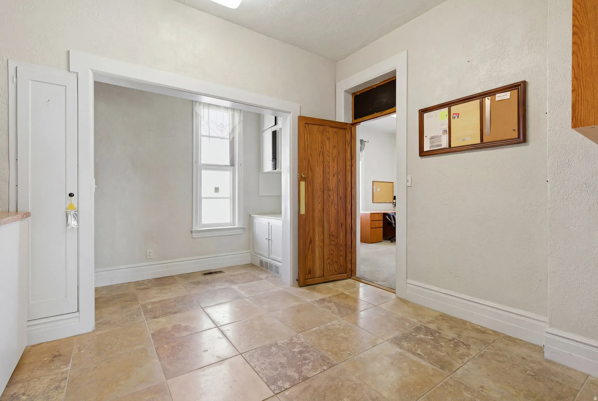 Interior space featuring baseboards and a textured wall