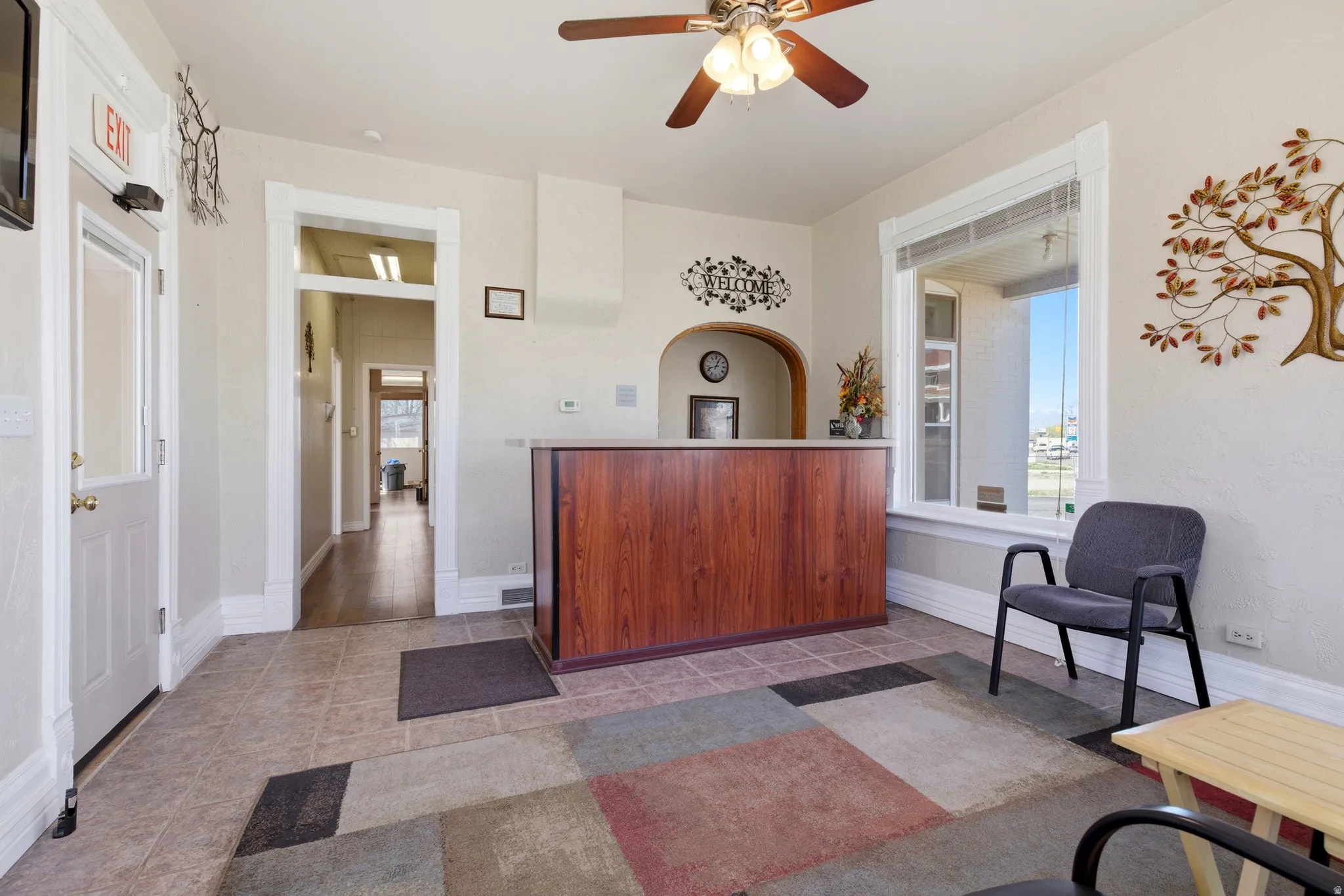 Living area featuring plenty of natural light, a ceiling fan, and light tile patterned floors