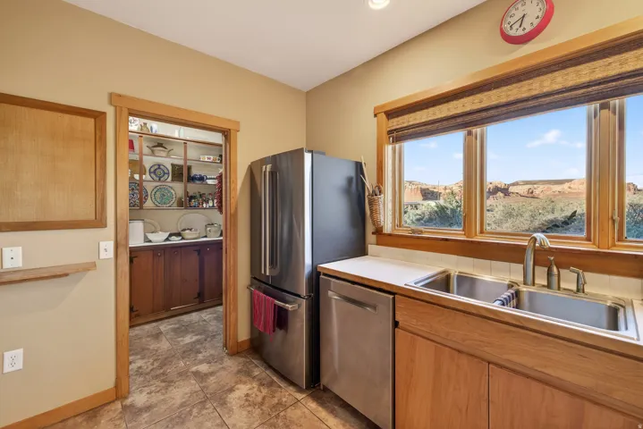 Kitchen with stainless steel appliances, light countertops, and light tile patterned floors