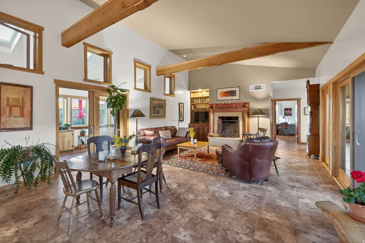 Dining area featuring a fireplace with raised hearth and lofted ceiling
