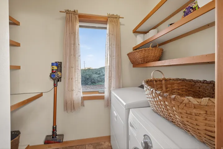 Laundry room with washer and clothes dryer and baseboards
