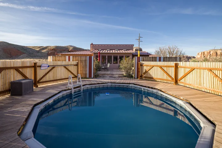 View of pool with a fenced backyard and a wooden deck