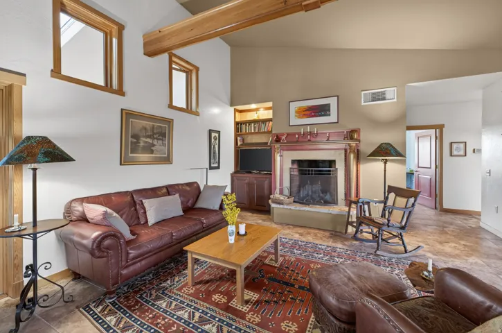 Living area featuring a fireplace, lofted ceiling, and built in features