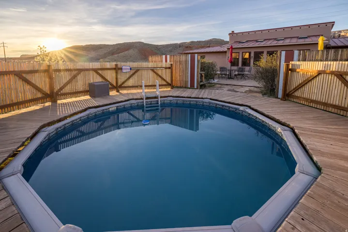 View of swimming pool with a fenced backyard and a deck with mountain view