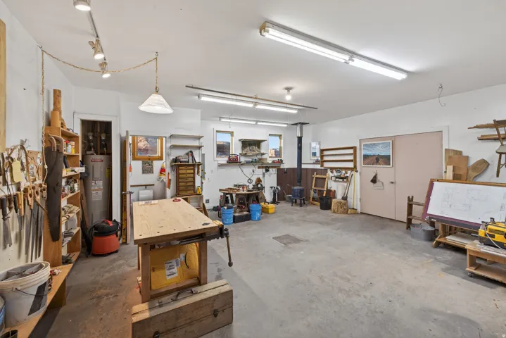 Garage with electric water heater and a workshop area