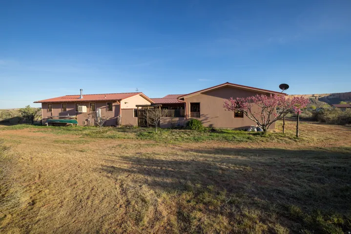 Rear view of property featuring a yard and a metal roof