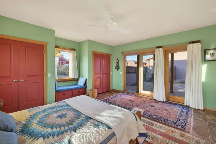 Bedroom featuring access to exterior, multiple closets, and ceiling fan