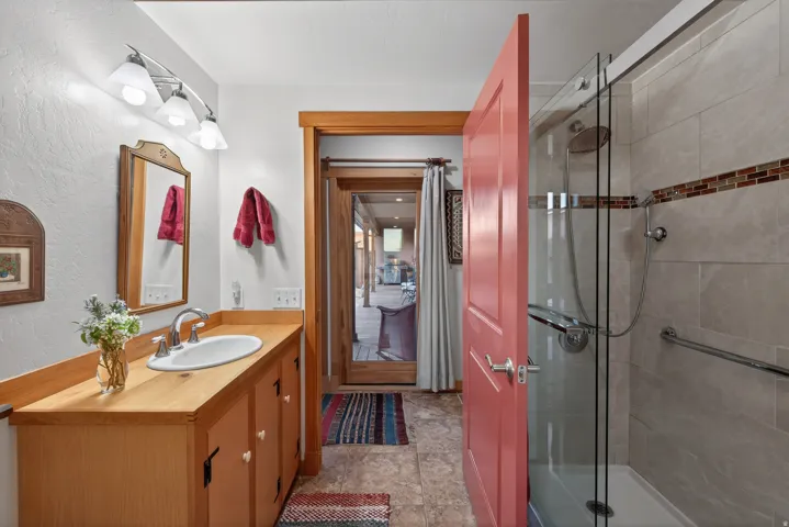 Full bath with vanity, a stall shower, and a textured wall