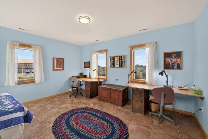 Bedroom with a desk and light tile patterned floors