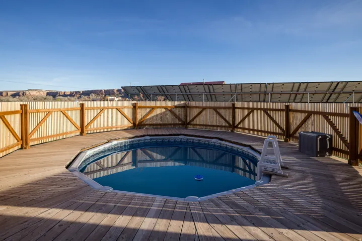 View of swimming pool featuring a wooden deck and a fenced backyard
