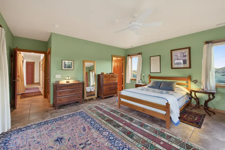 Bedroom featuring ceiling fan and dark tile patterned flooring