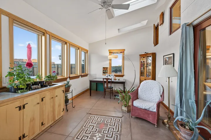 Sunroom featuring vaulted ceiling, a skylight, and french doors