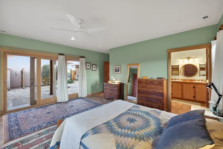 Bedroom featuring access to outside, a ceiling fan, and ensuite bathroom