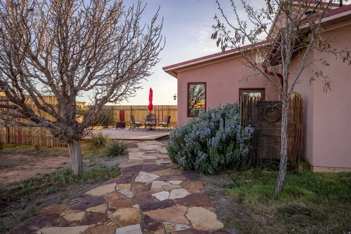 Back of house at dusk with a fenced backyard, a patio, and stucco siding