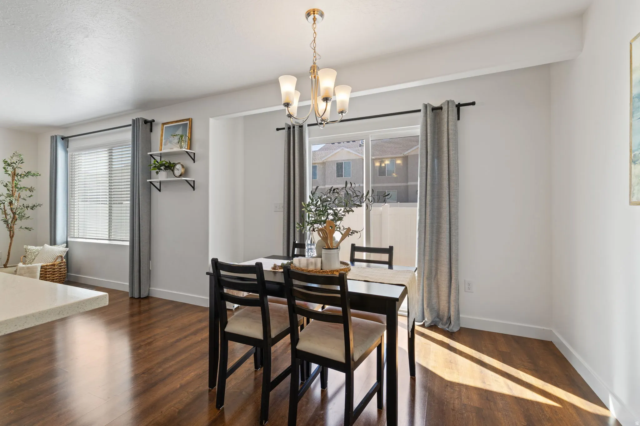 Dining room with dark wood-style floors and suspended lighting