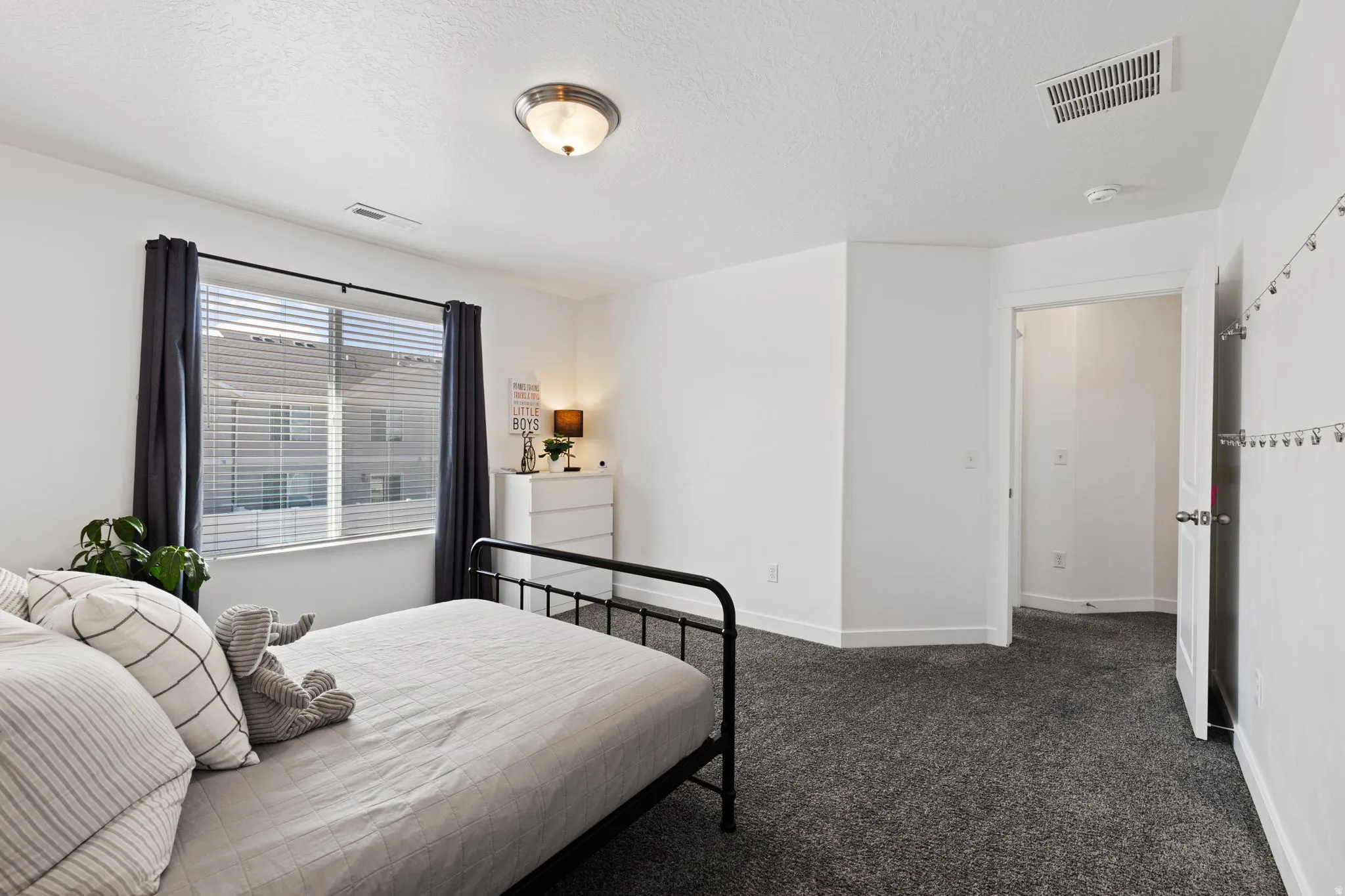 Bedroom featuring dark carpet and a textured ceiling