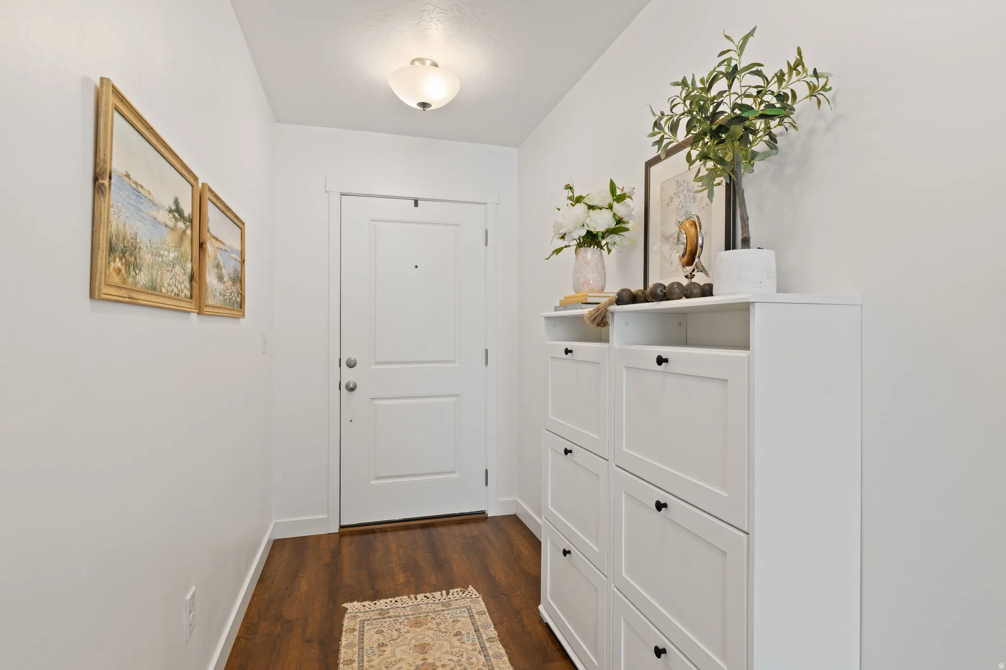 Doorway to outside featuring baseboards and wood finished floors