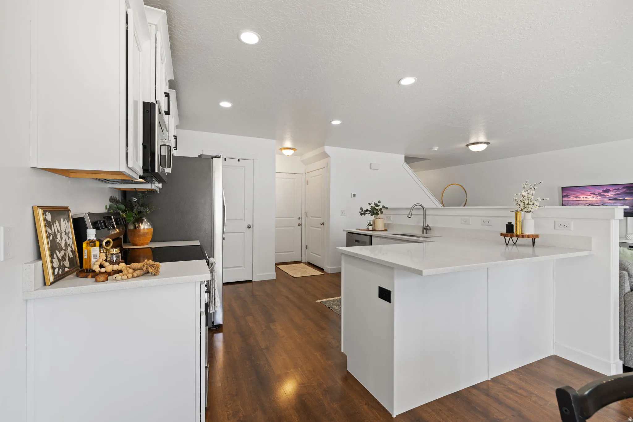 Kitchen with white cabinets, electric stove, dark wood-style flooring, a textured ceiling, and recessed lighting