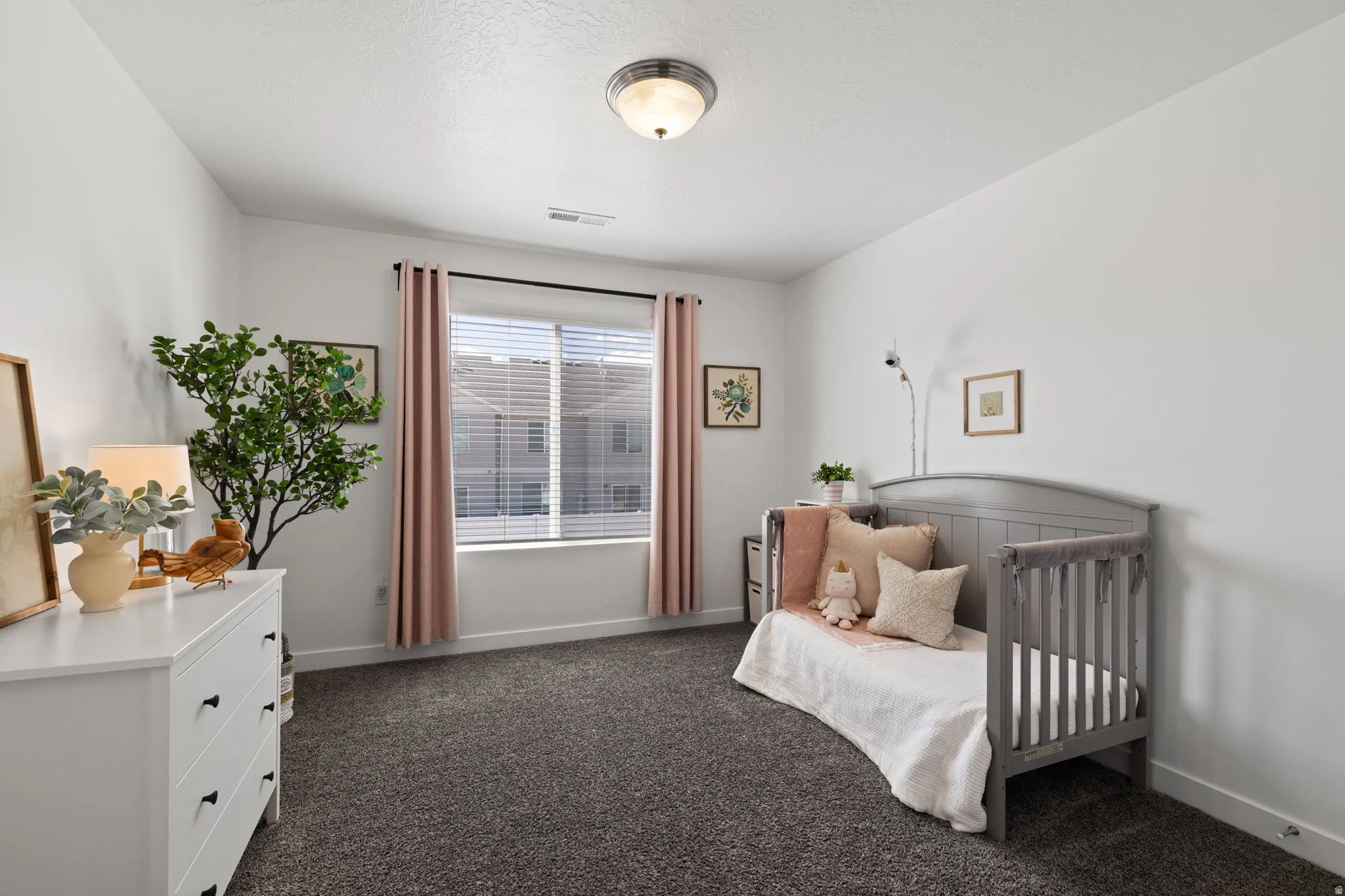 Bedroom with dark carpet and baseboards