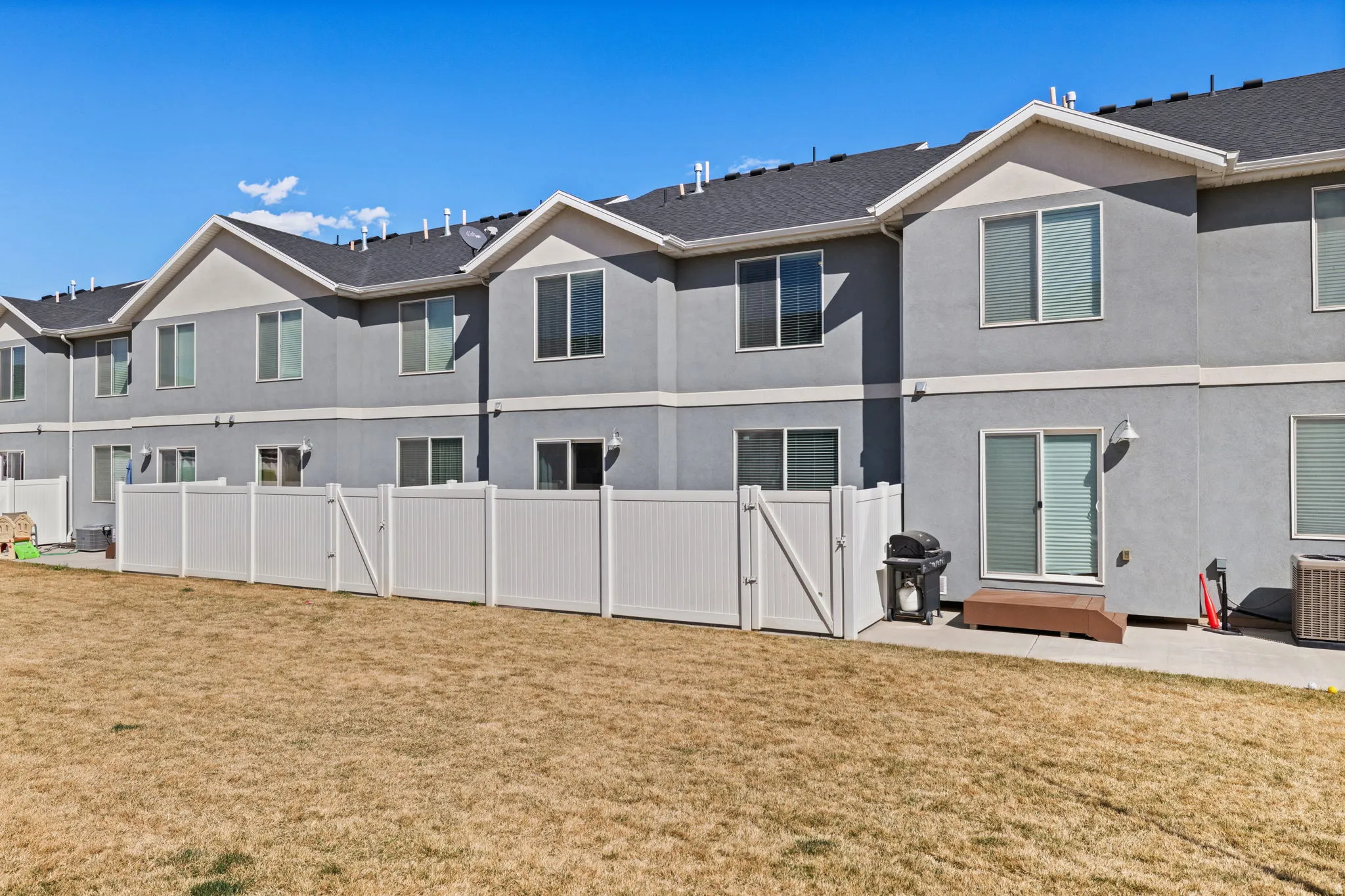 Back of property featuring a gate, stucco siding, and a patio