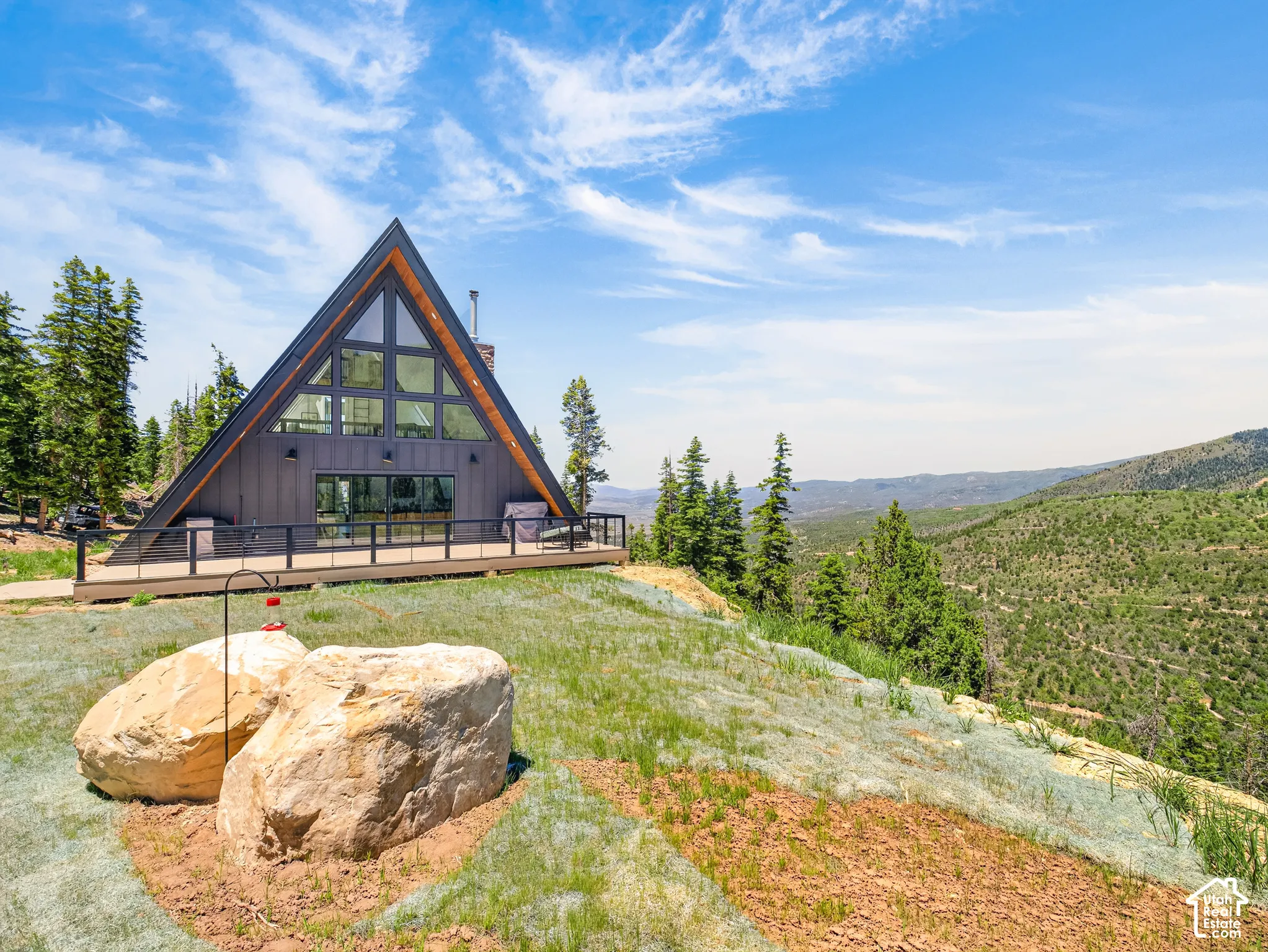 Modern A-frame architecture featuring a dark siding facade and a steeply pitched roof