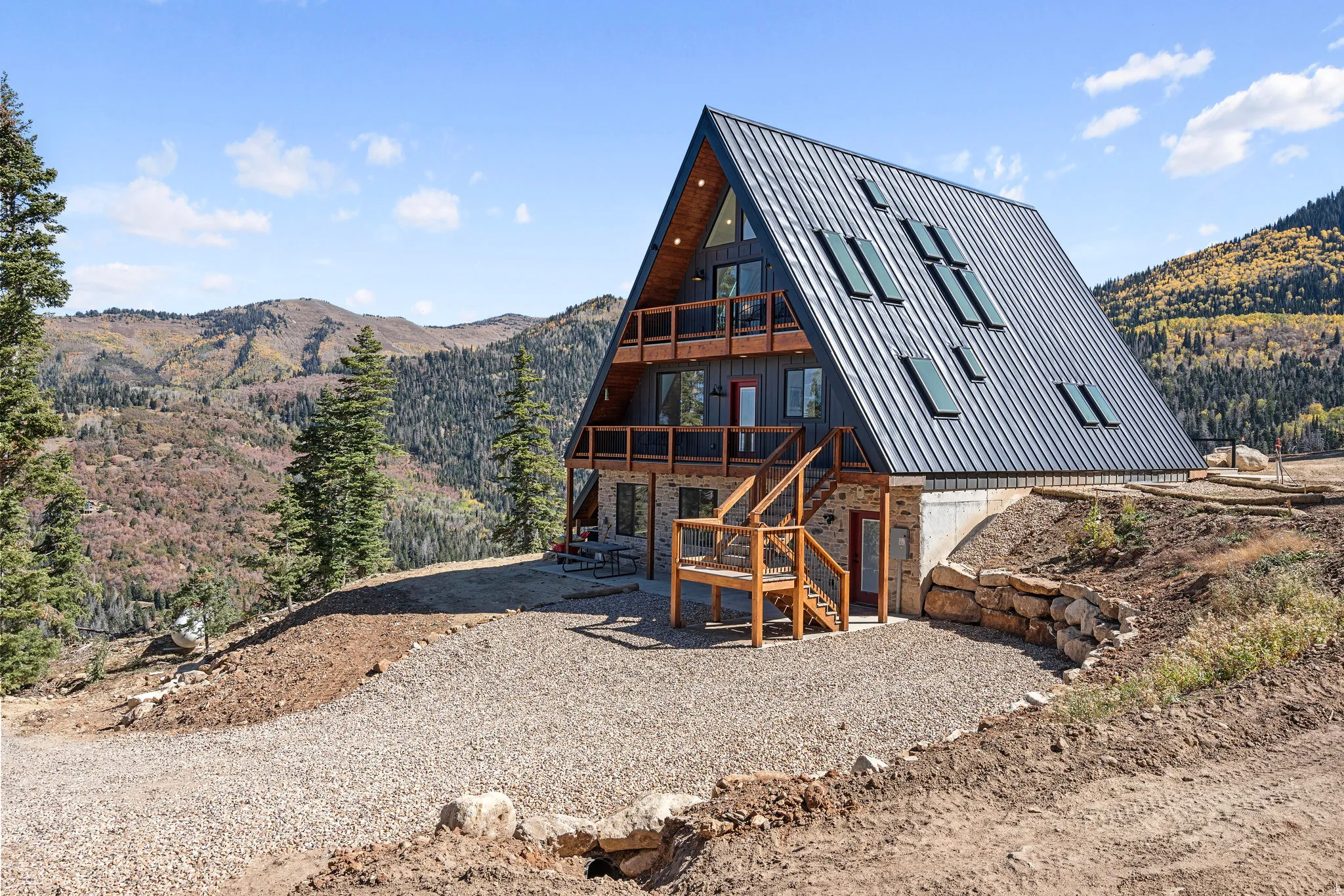 Back of house with a mountain view and stone siding