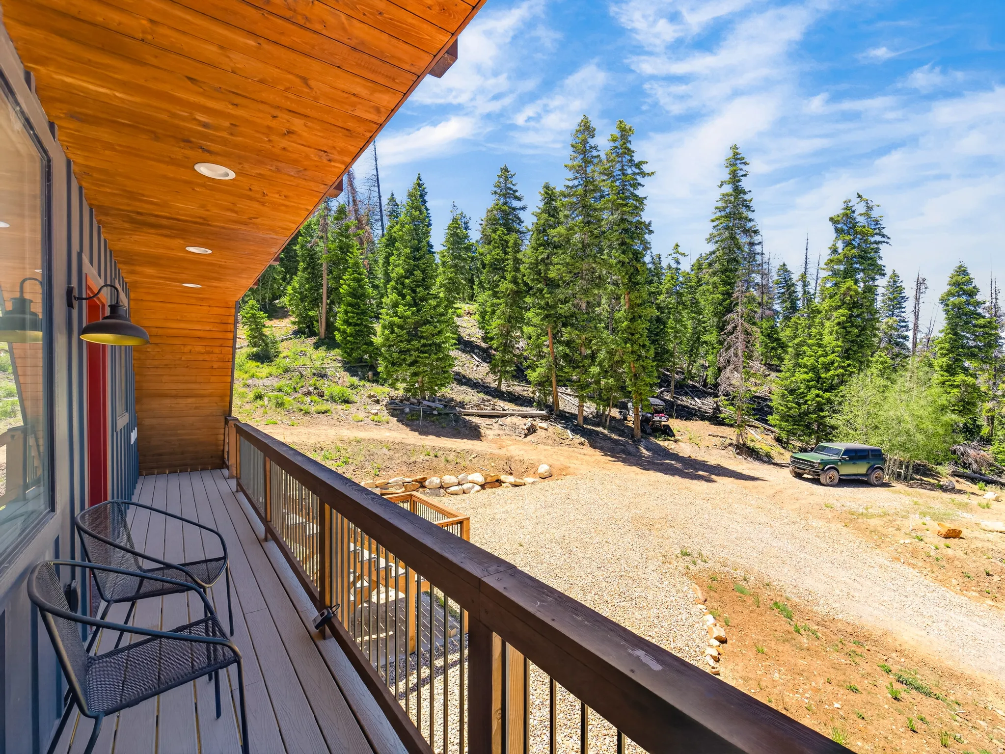 Exterior deck featuring wood-finish flooring, a dark wood-finish railing with metal balusters, and a natural wood-finish ceiling with recessed lighting