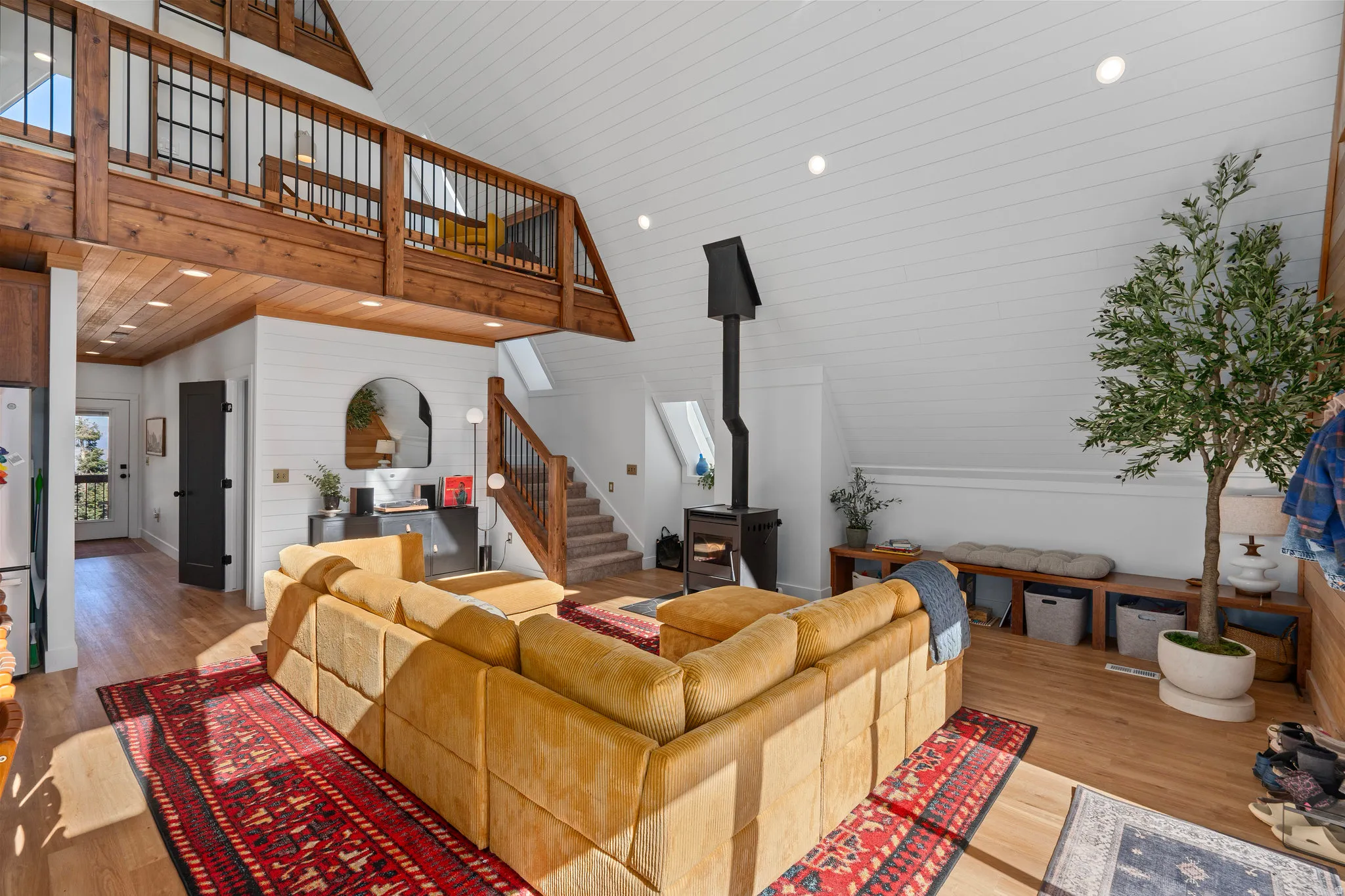Living room with recessed lighting, wood finished floors, a vaulted wood ceiling, and a wood stove