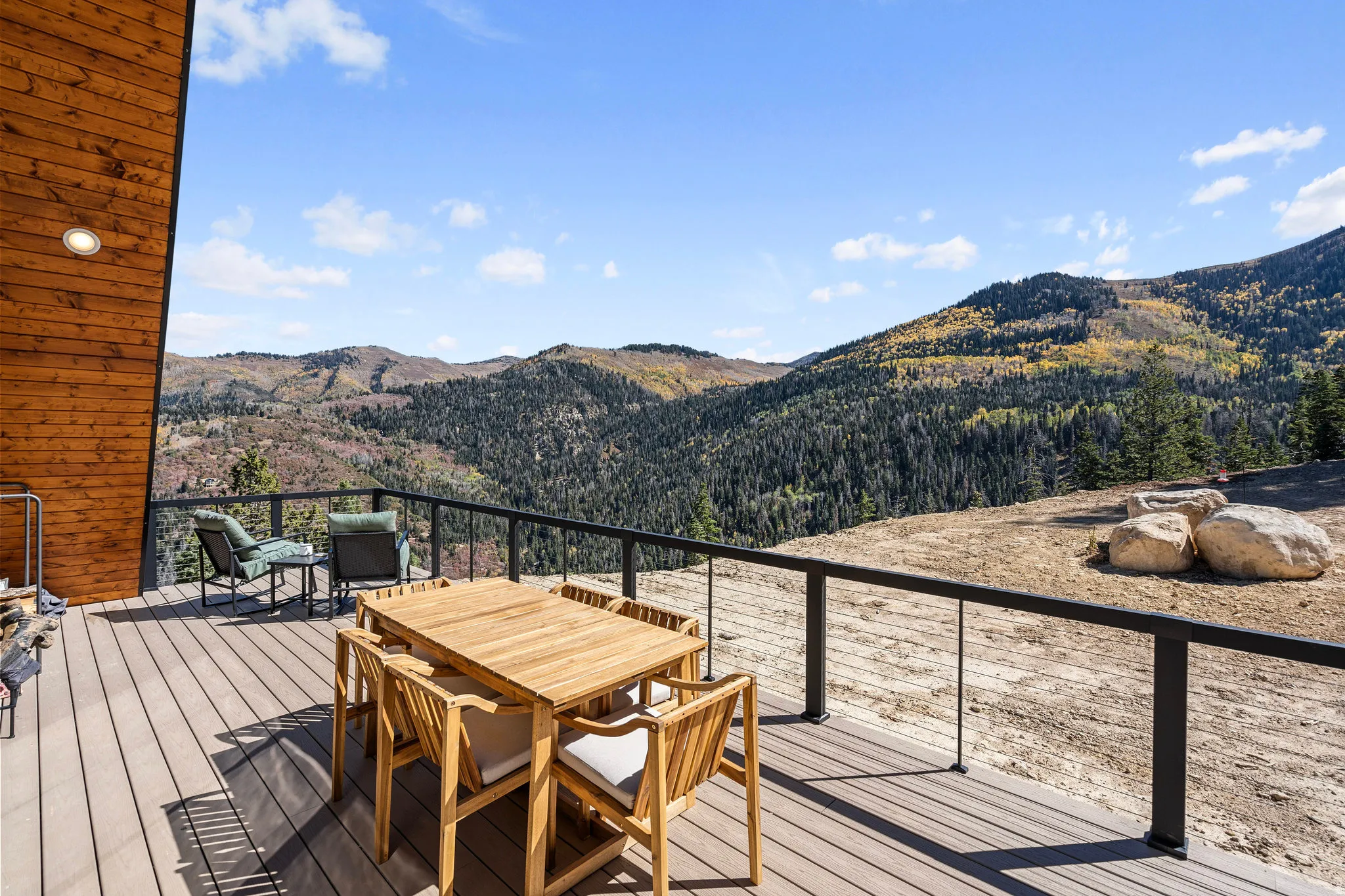 Wooden deck with outdoor dining space and a mountain view
