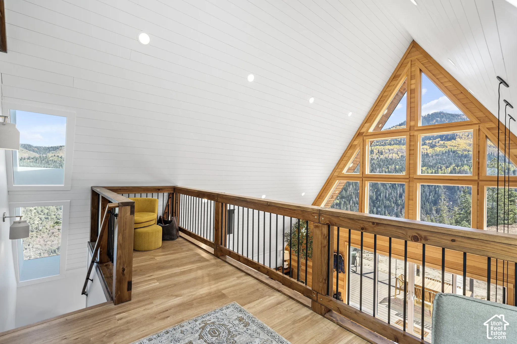 Hall featuring a mountain view, wood finished floors, a high ceiling, recessed lighting, and an upstairs landing