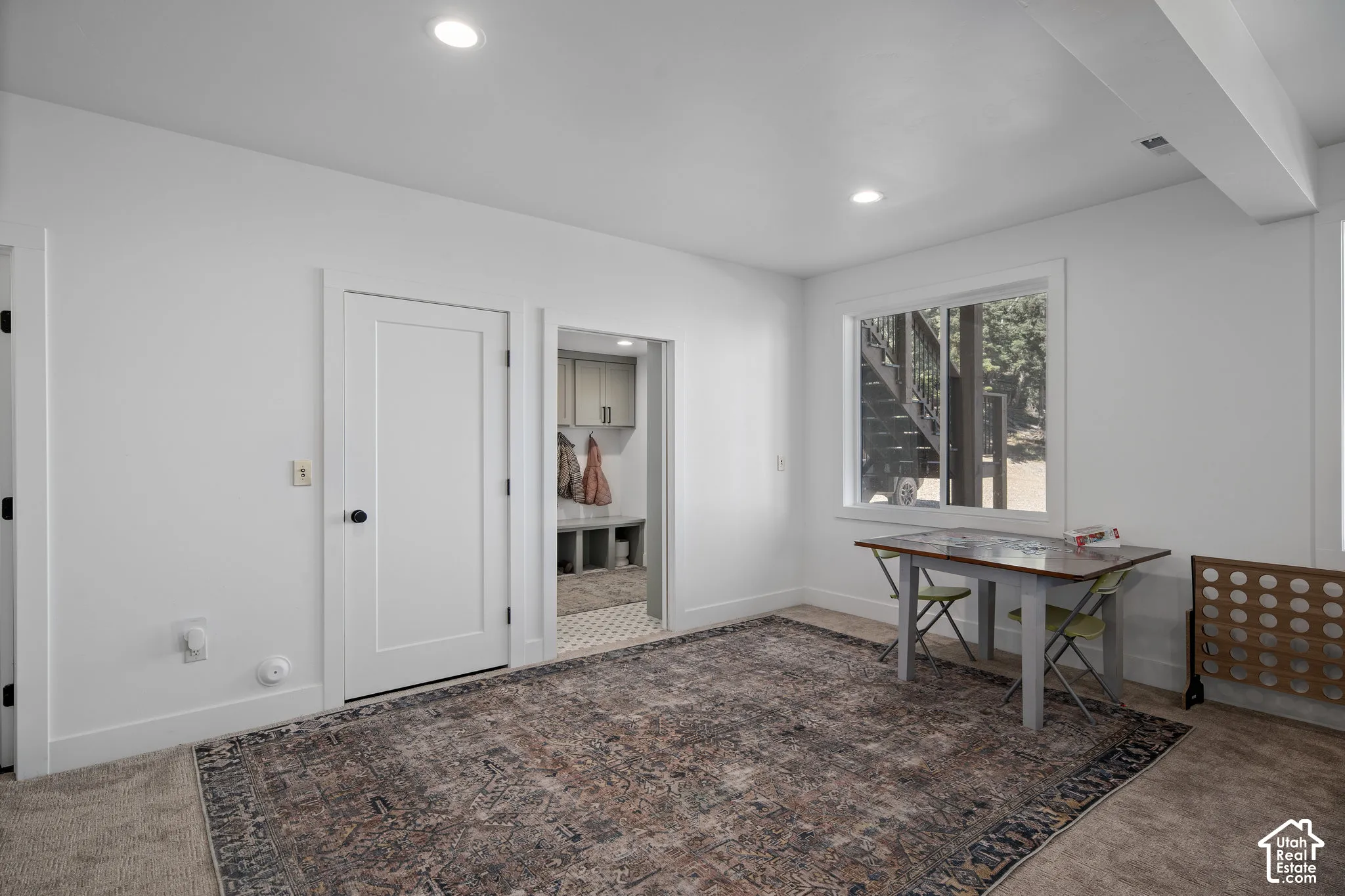 Home office with dark carpet and recessed lighting