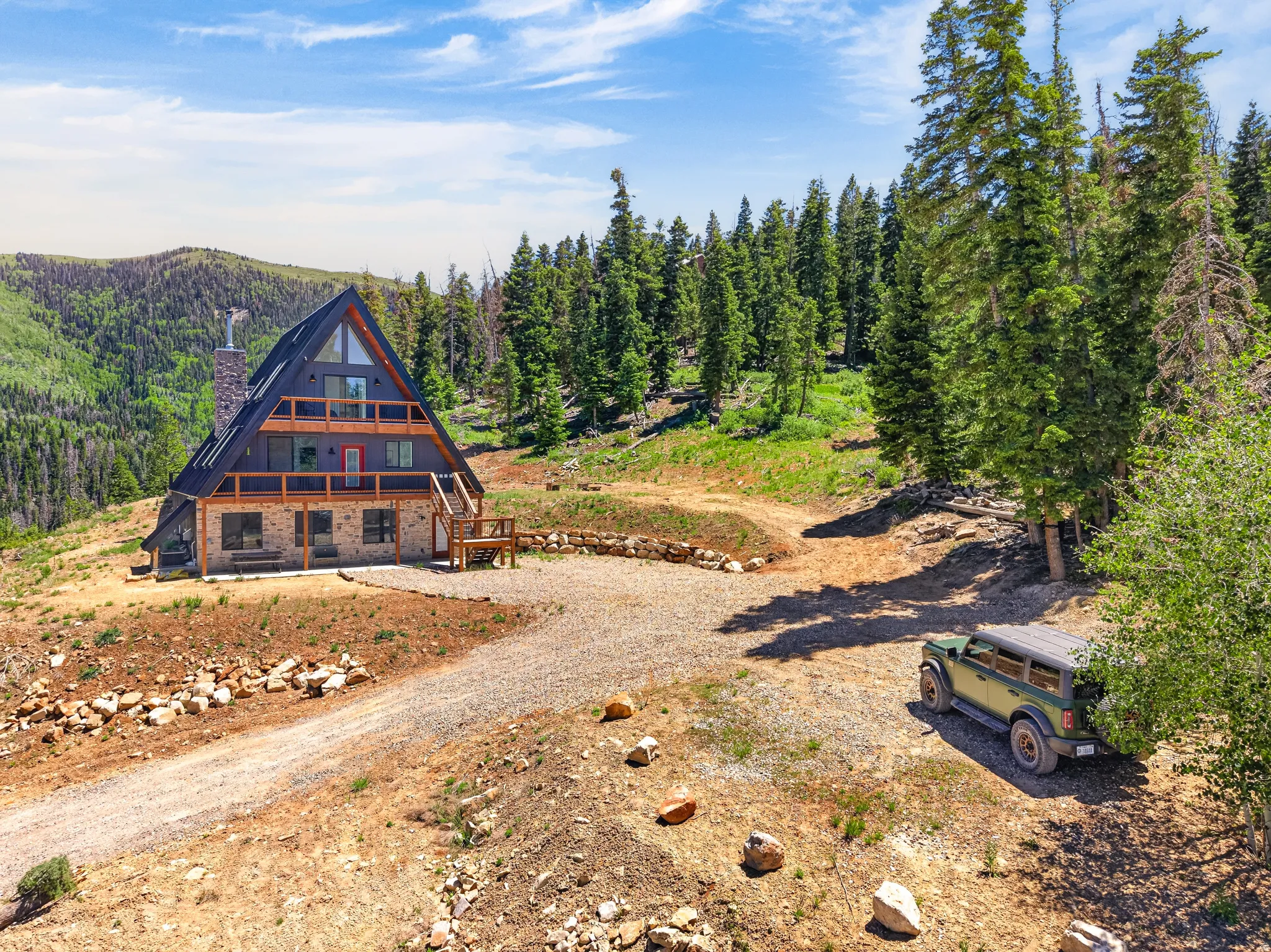 A-frame property with stone veneer lower level, dark siding, and multiple balconies