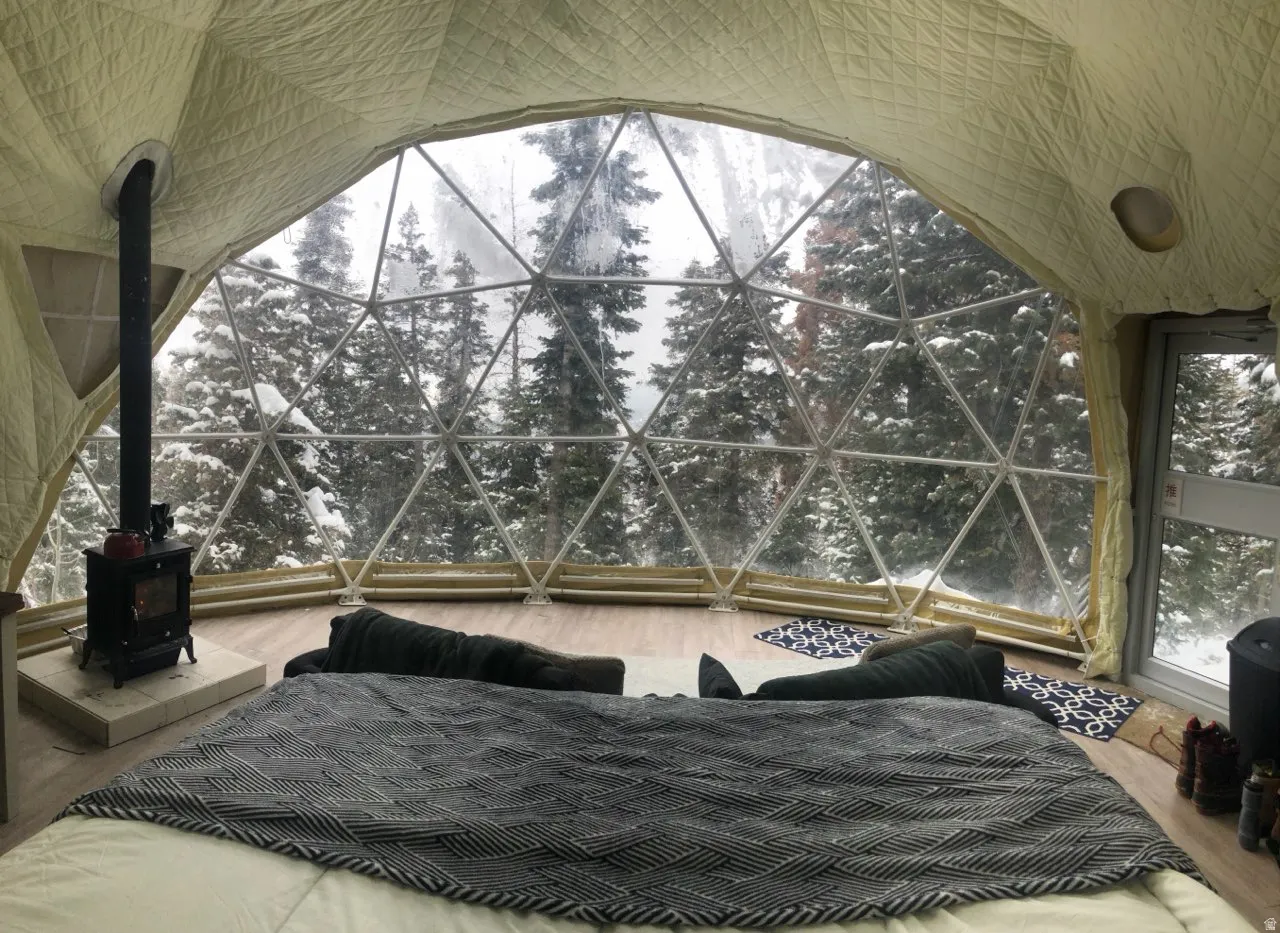 Bedroom with a wood stove and wood finished floors