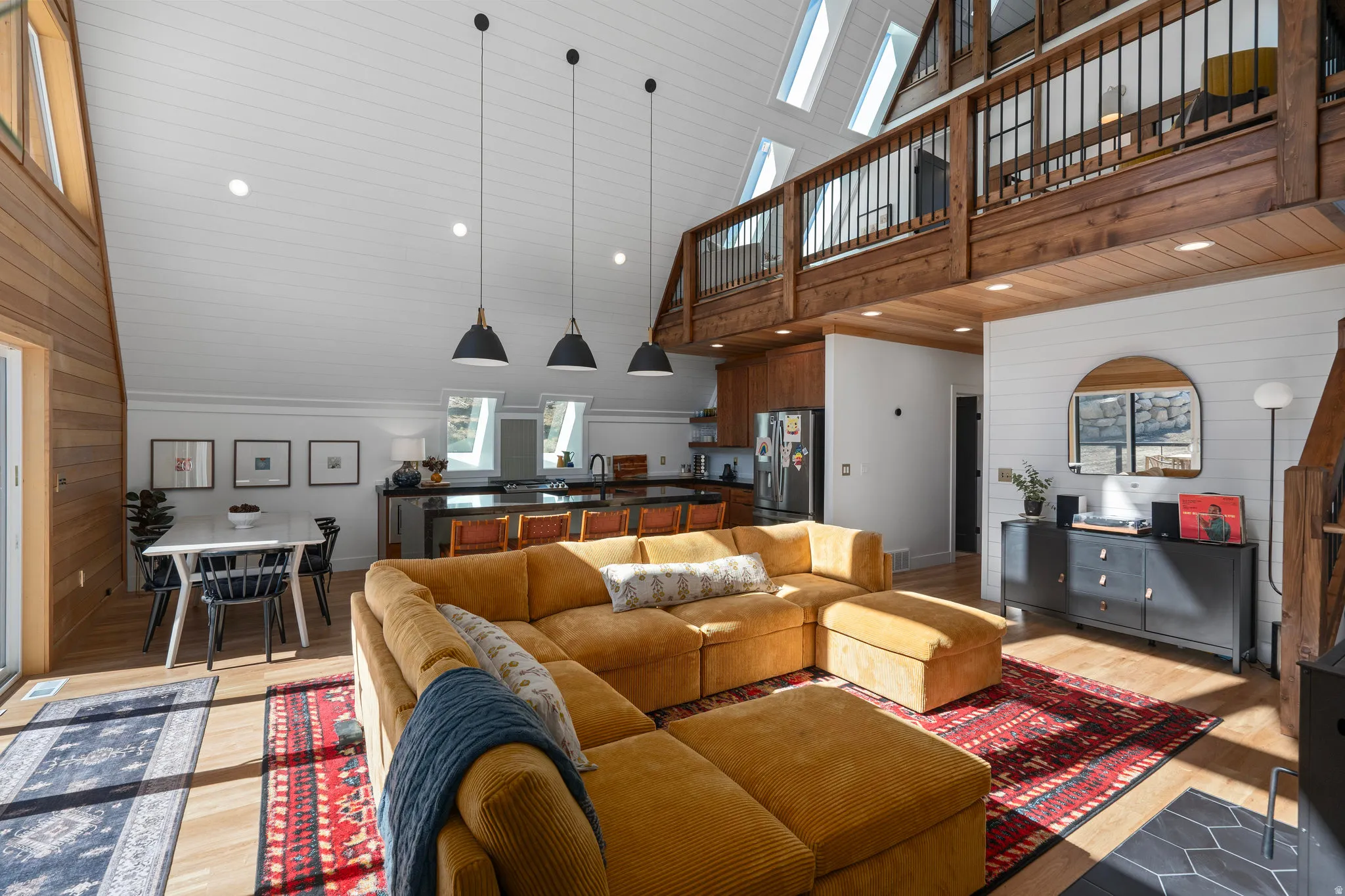 Living room featuring wooden walls, light wood-style flooring, recessed lighting, and a vaulted wood ceiling
