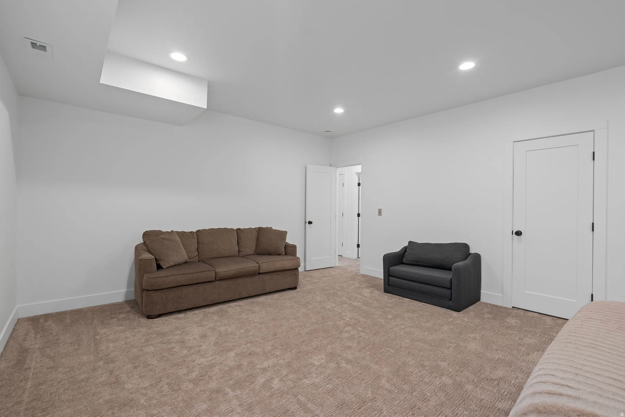 Living room with recessed lighting and light colored carpet