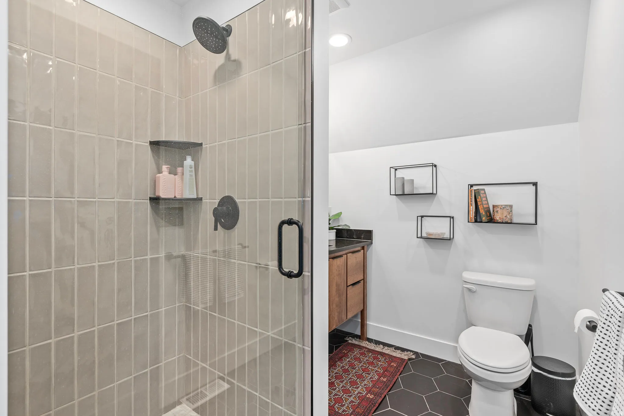 Bathroom with vanity, a stall shower, and dark tile patterned flooring