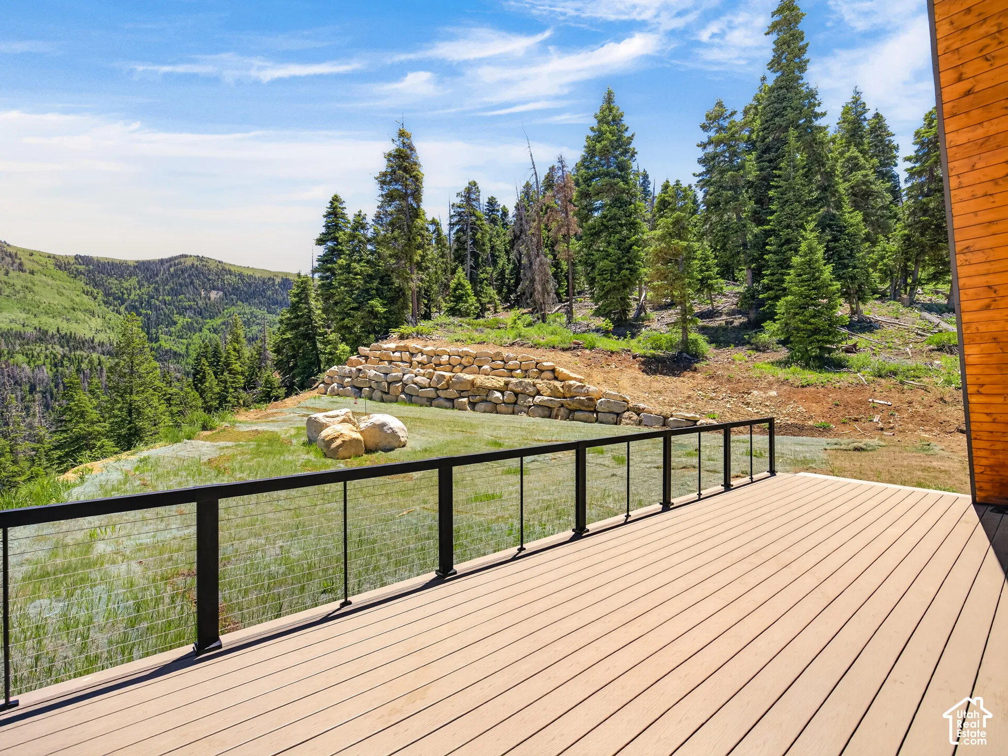 Expansive wood-finish deck with a black metal and cable railing system