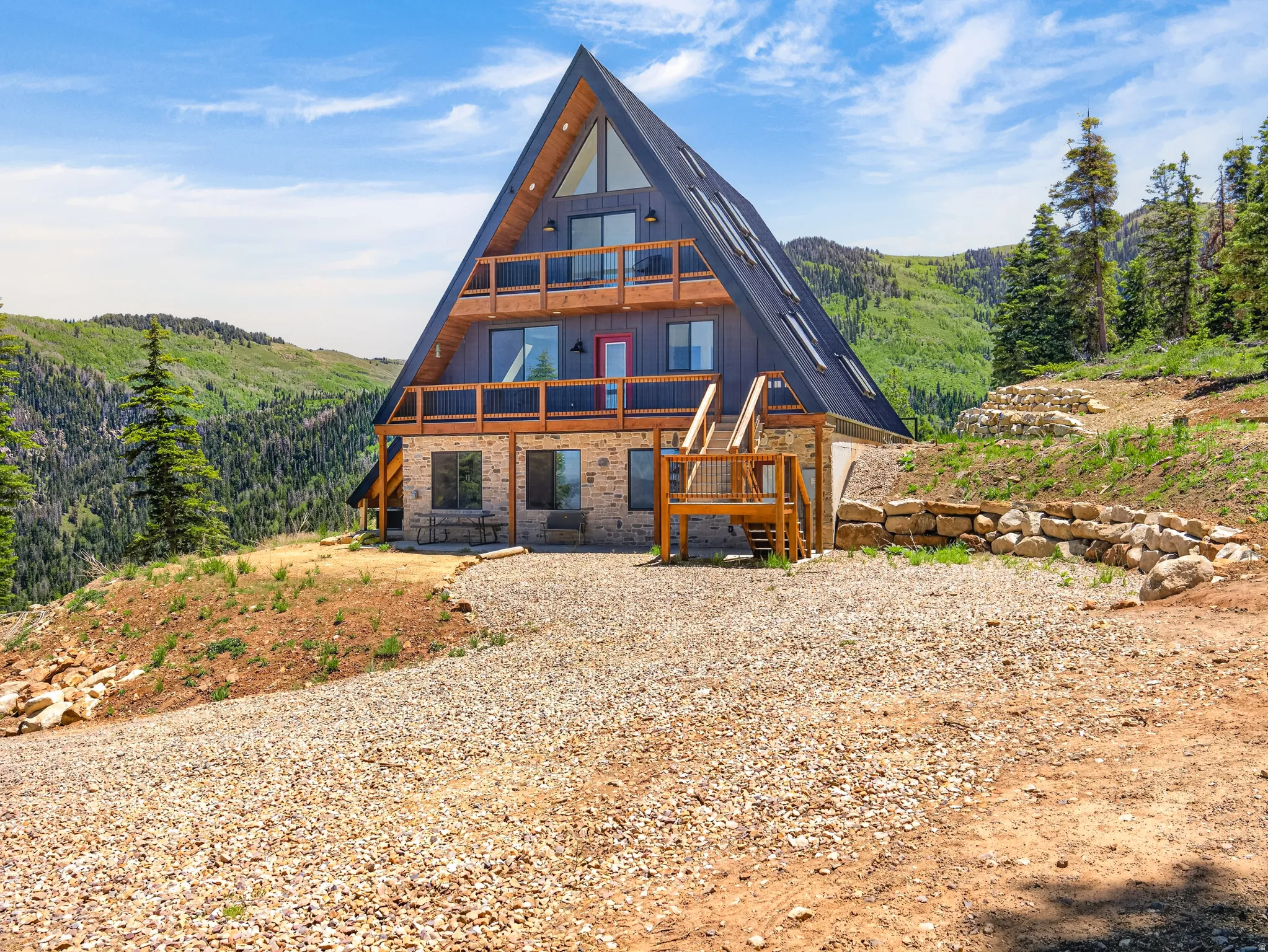 A-frame exterior featuring a stone base and wood-paneled upper levels