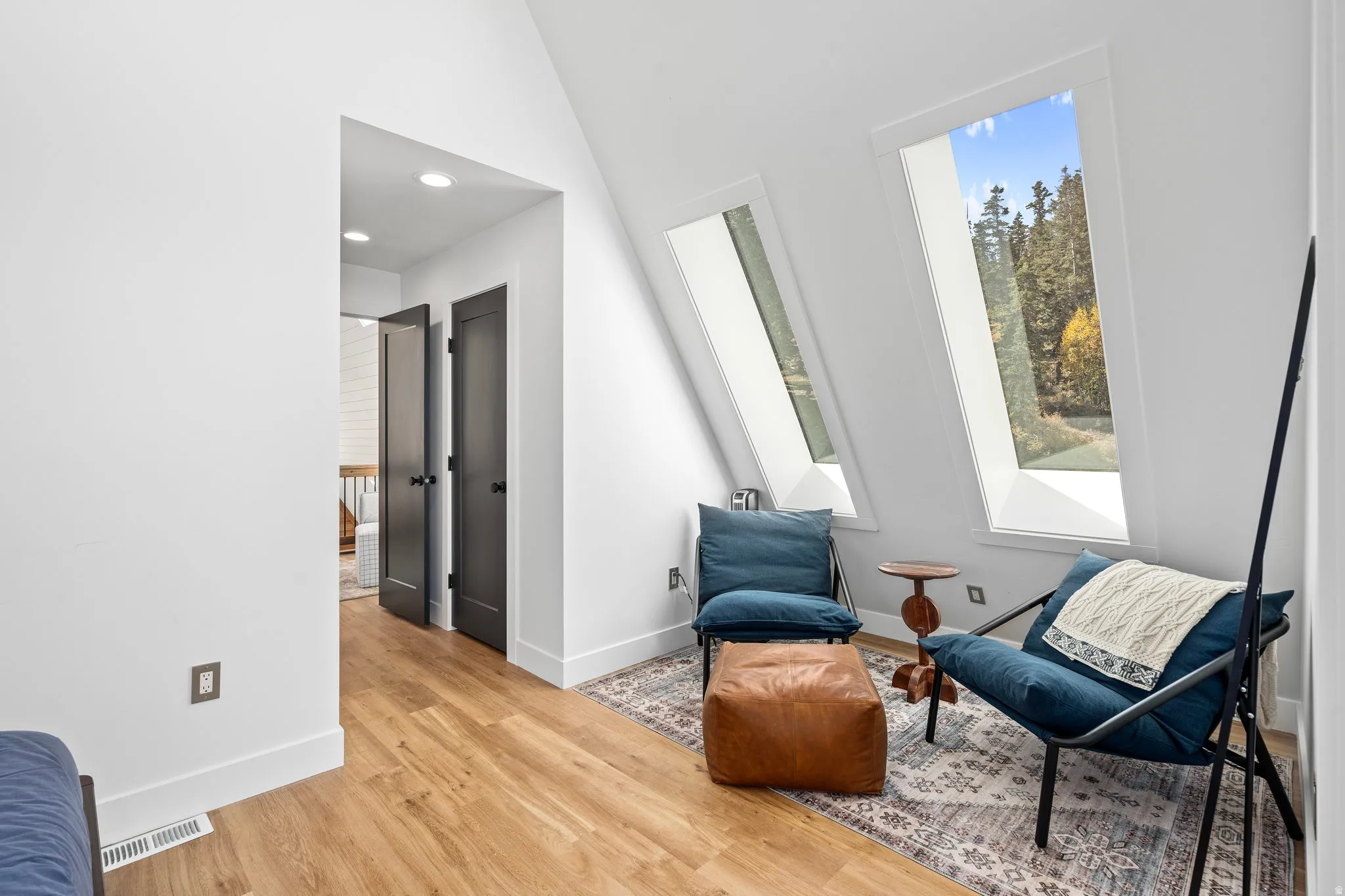 Sitting room featuring light wood-style flooring, recessed lighting, and a high ceiling