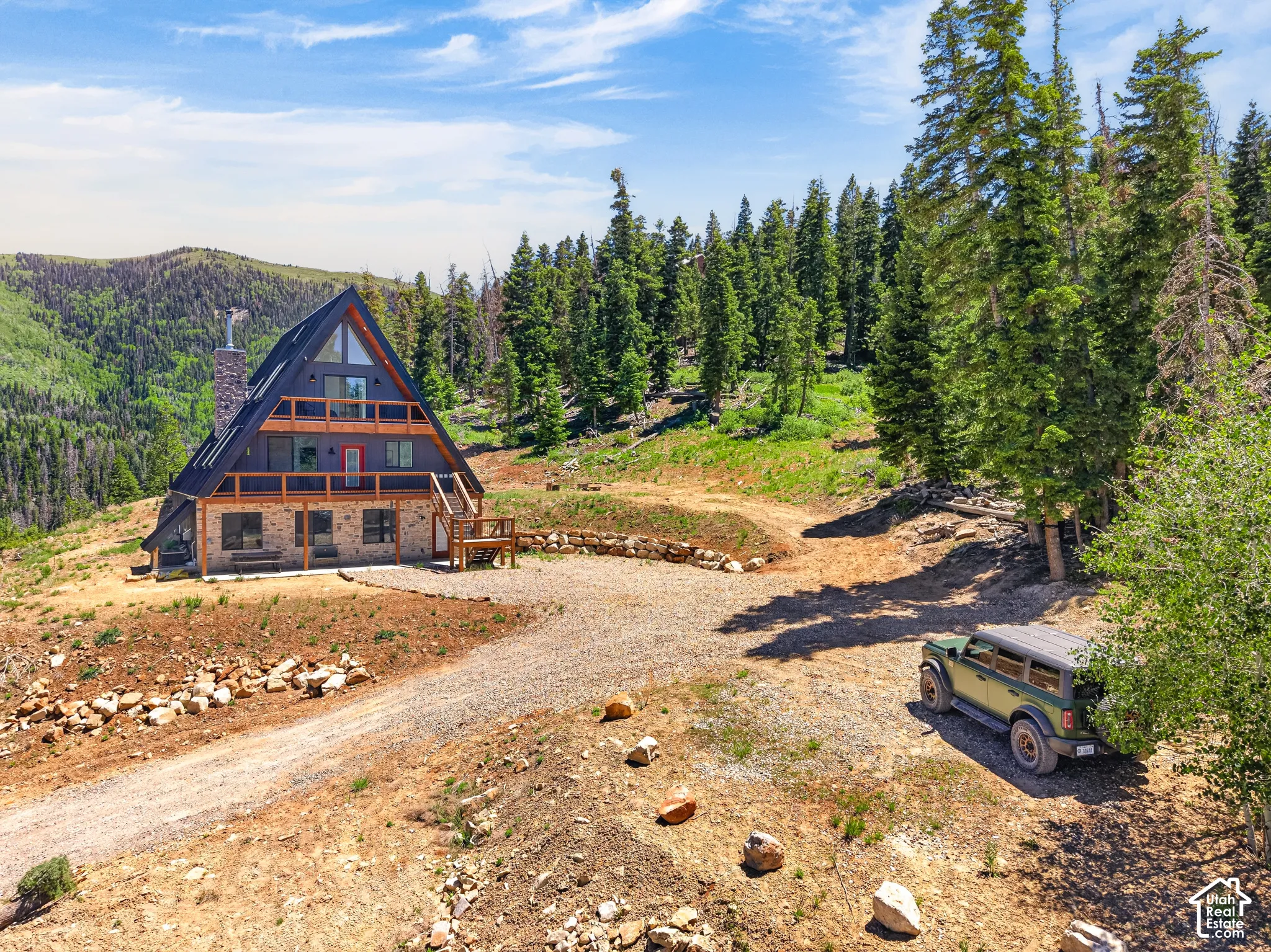 A-frame property with stone veneer lower level, dark siding, and multiple balconies
