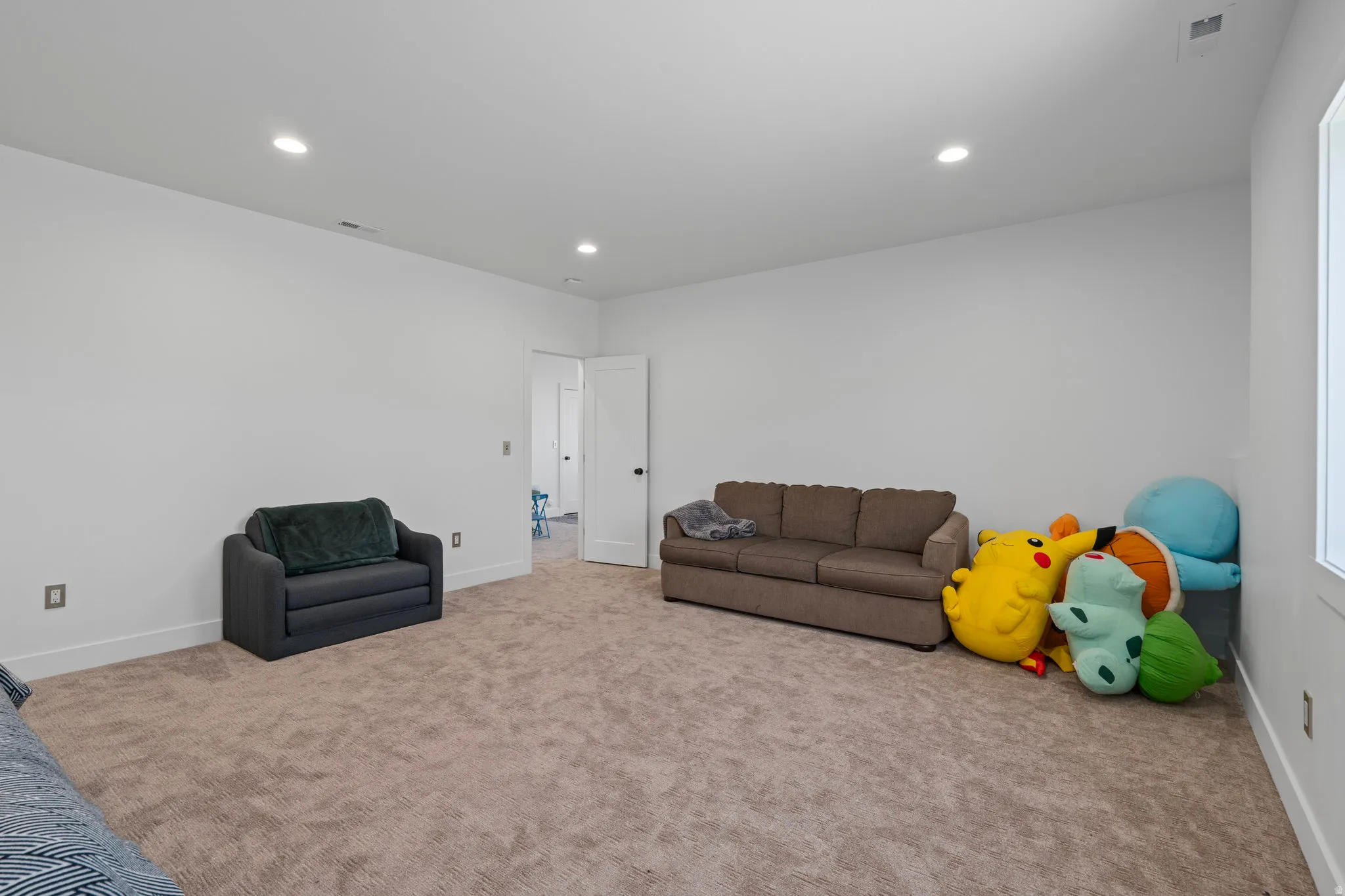 Carpeted living area featuring recessed lighting and baseboards