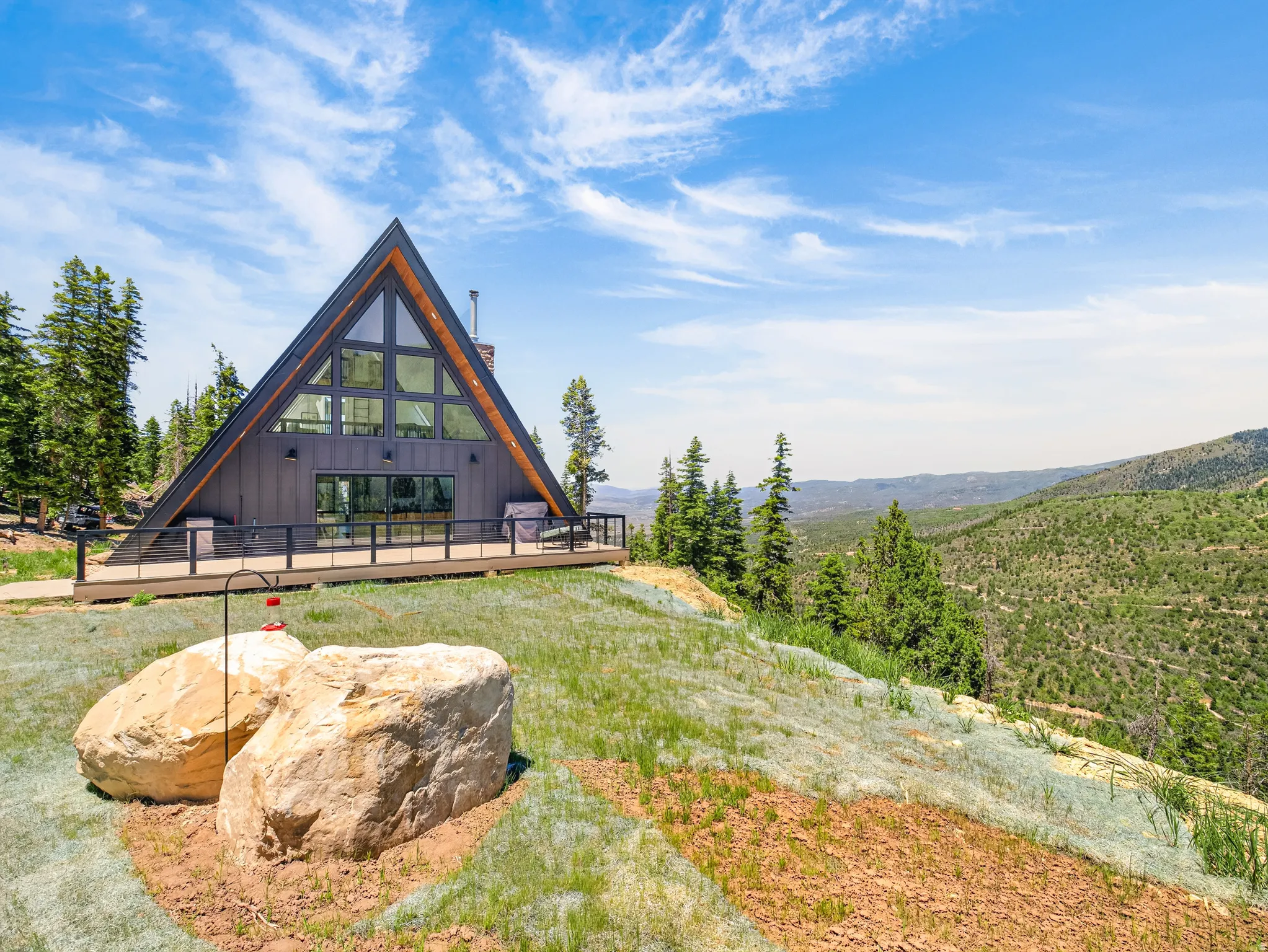 Modern A-frame architecture featuring a dark siding facade and a steeply pitched roof
