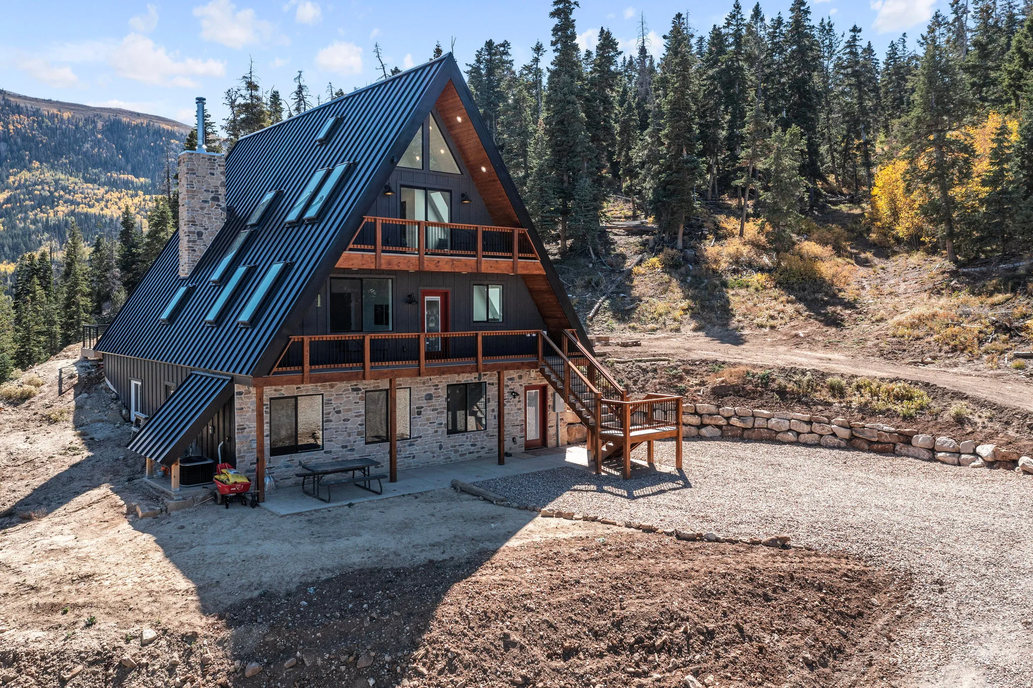 Rear view of house with a patio, a chimney, a deck, and a balcony