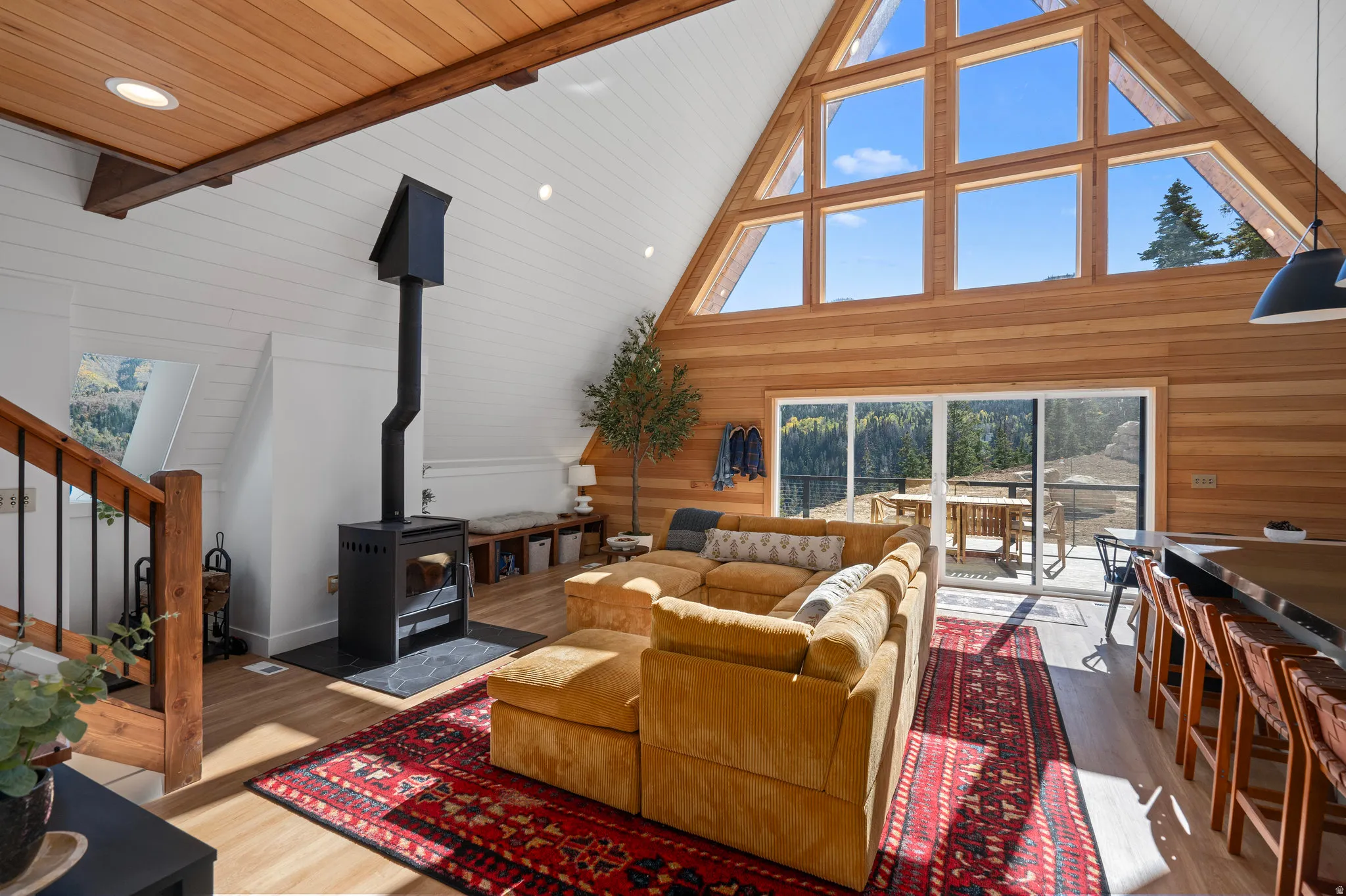 Living area featuring a wood stove, wood finished floors, wood walls, a high wood beamed ceiling, and recessed lighting