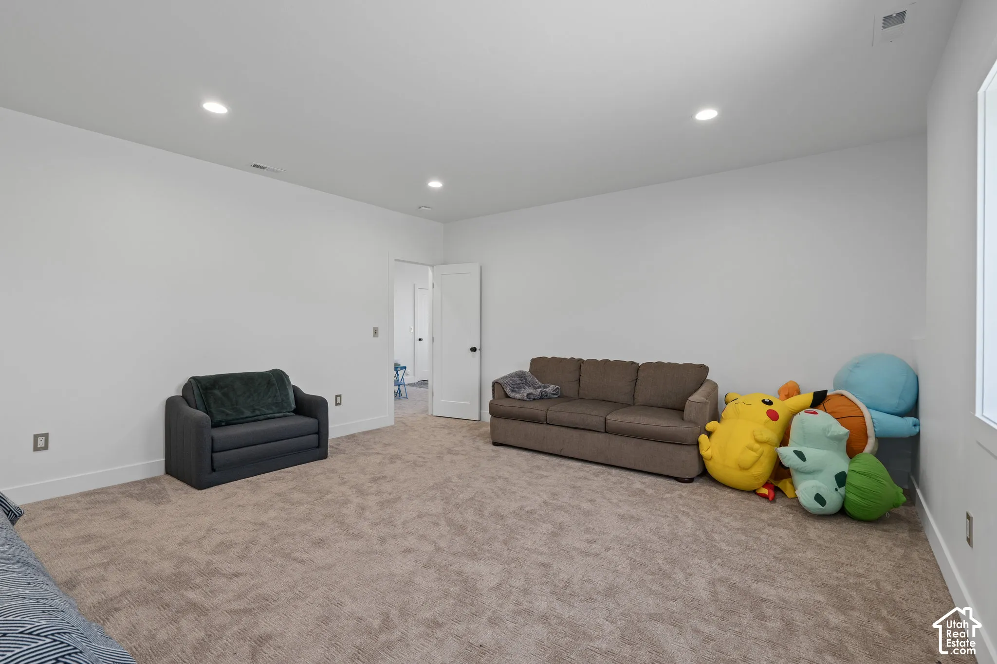 Carpeted living area featuring recessed lighting and baseboards