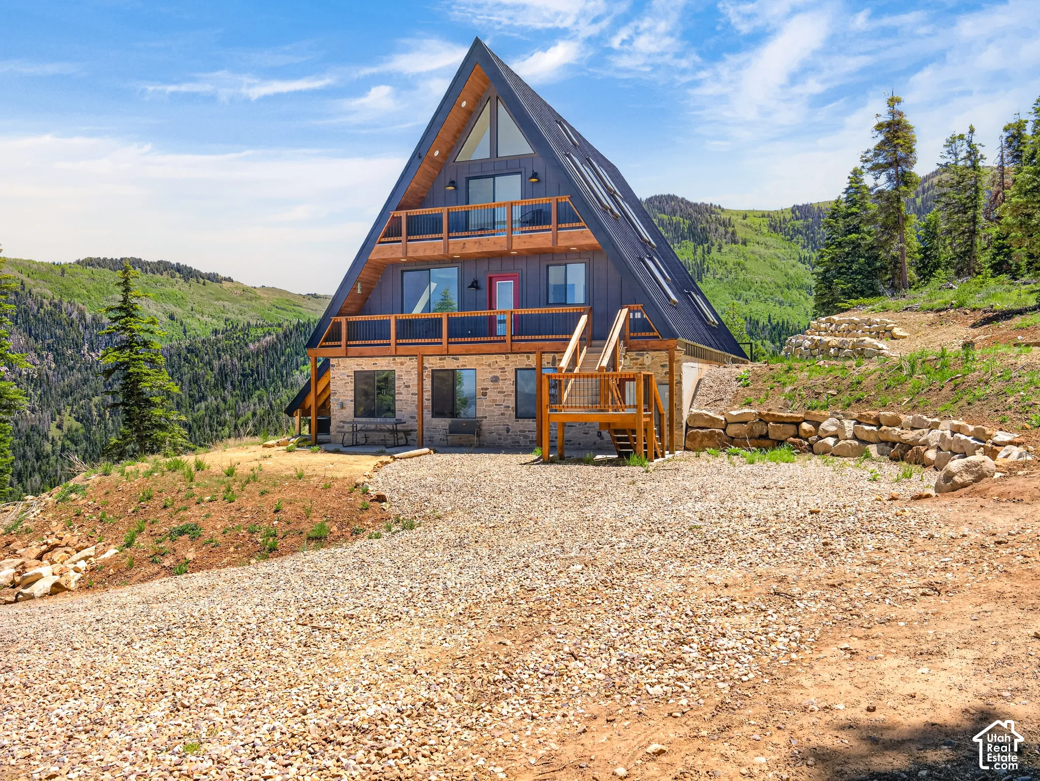 A-frame exterior featuring a stone base and wood-paneled upper levels