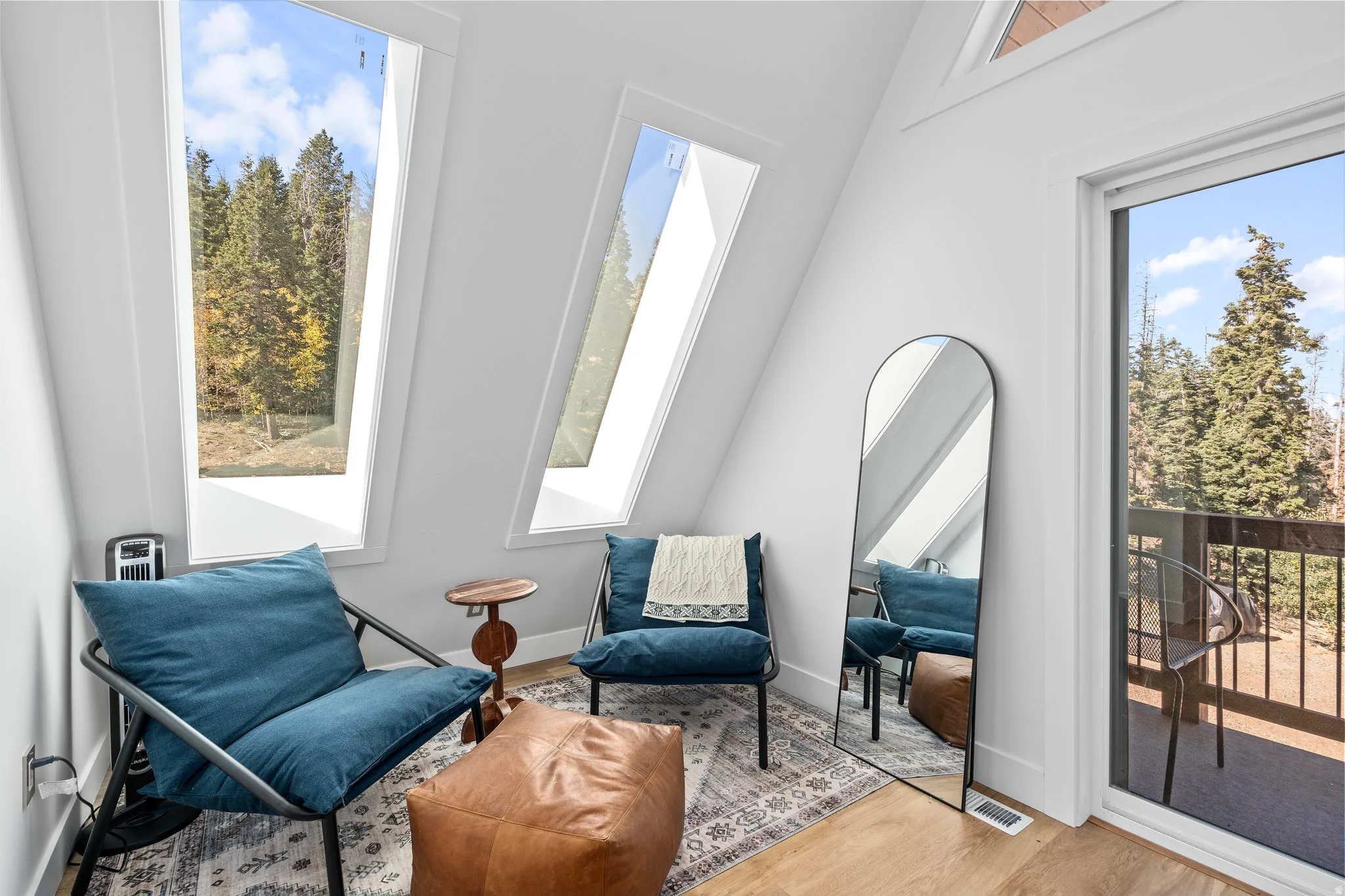Living area with light wood-style flooring and healthy amount of natural light