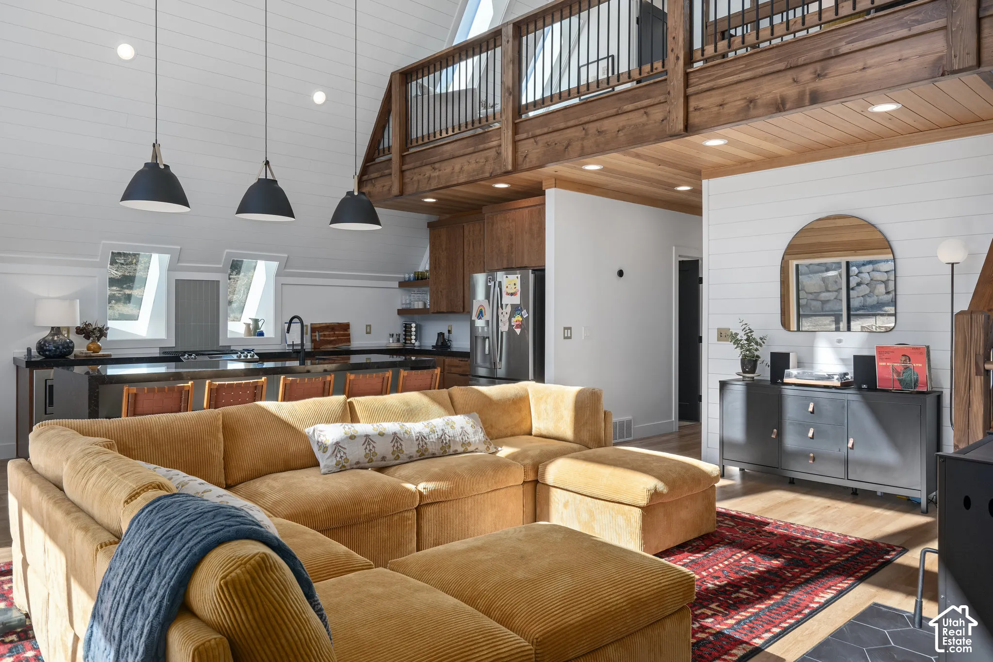 Living area with wooden walls, wood finished floors, recessed lighting, and a high wood ceiling
