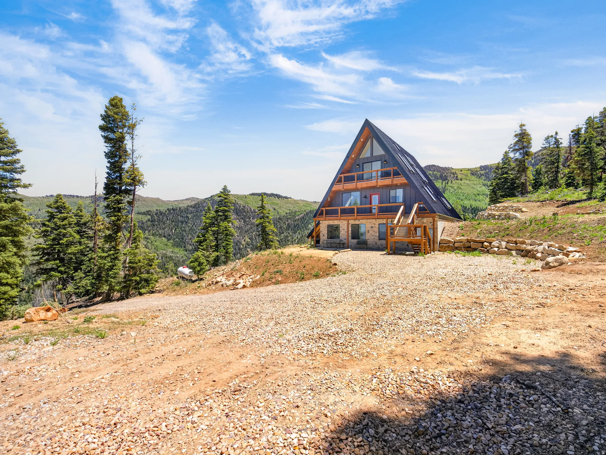 A-frame residence featuring a dark-pitched roof and light-toned siding