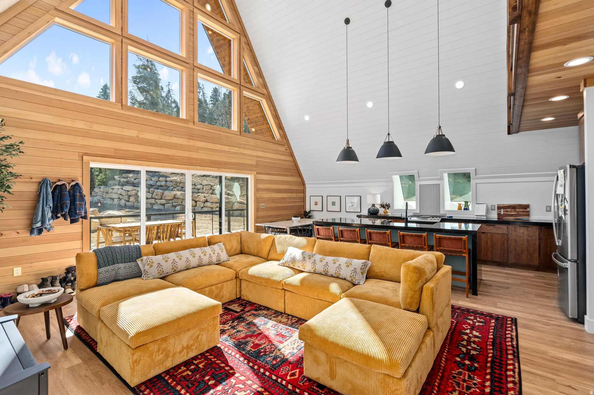 Living area with light wood finished floors, wood walls, recessed lighting, and a high wood ceiling